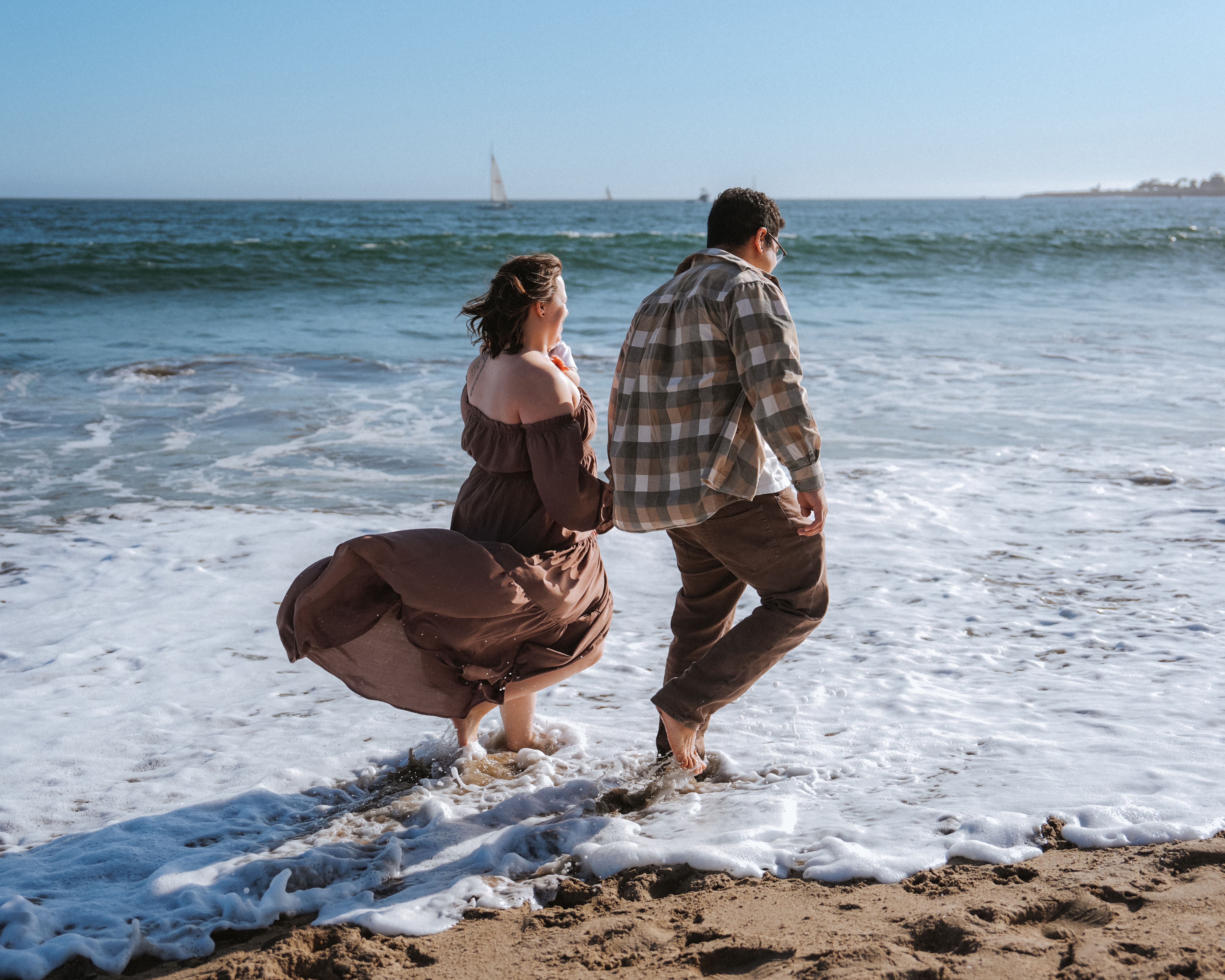 Family walking into the surf during a beach portrait session in Pacifica, California