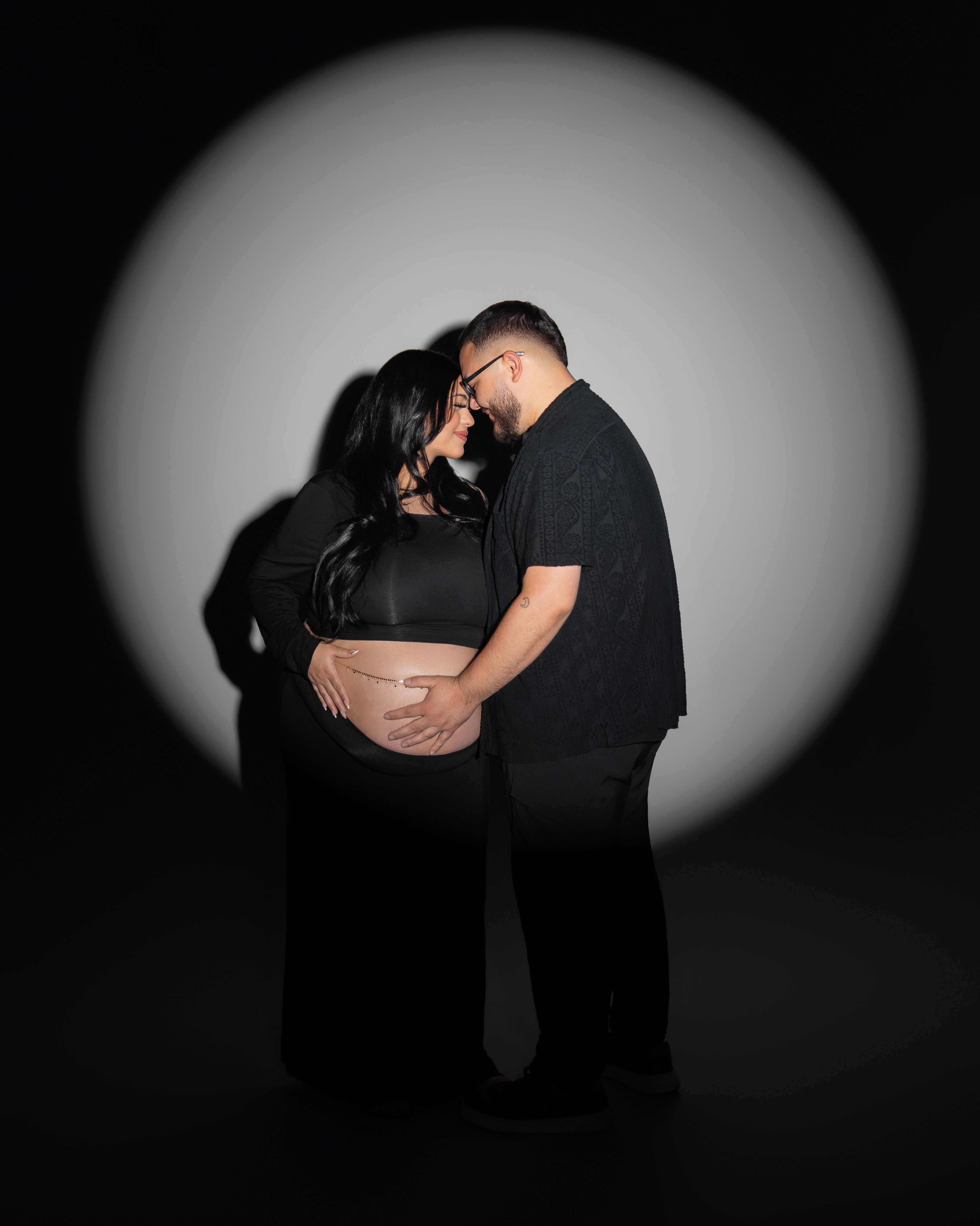 Pregnant couple under a studio spotlight in Santa Clara, California