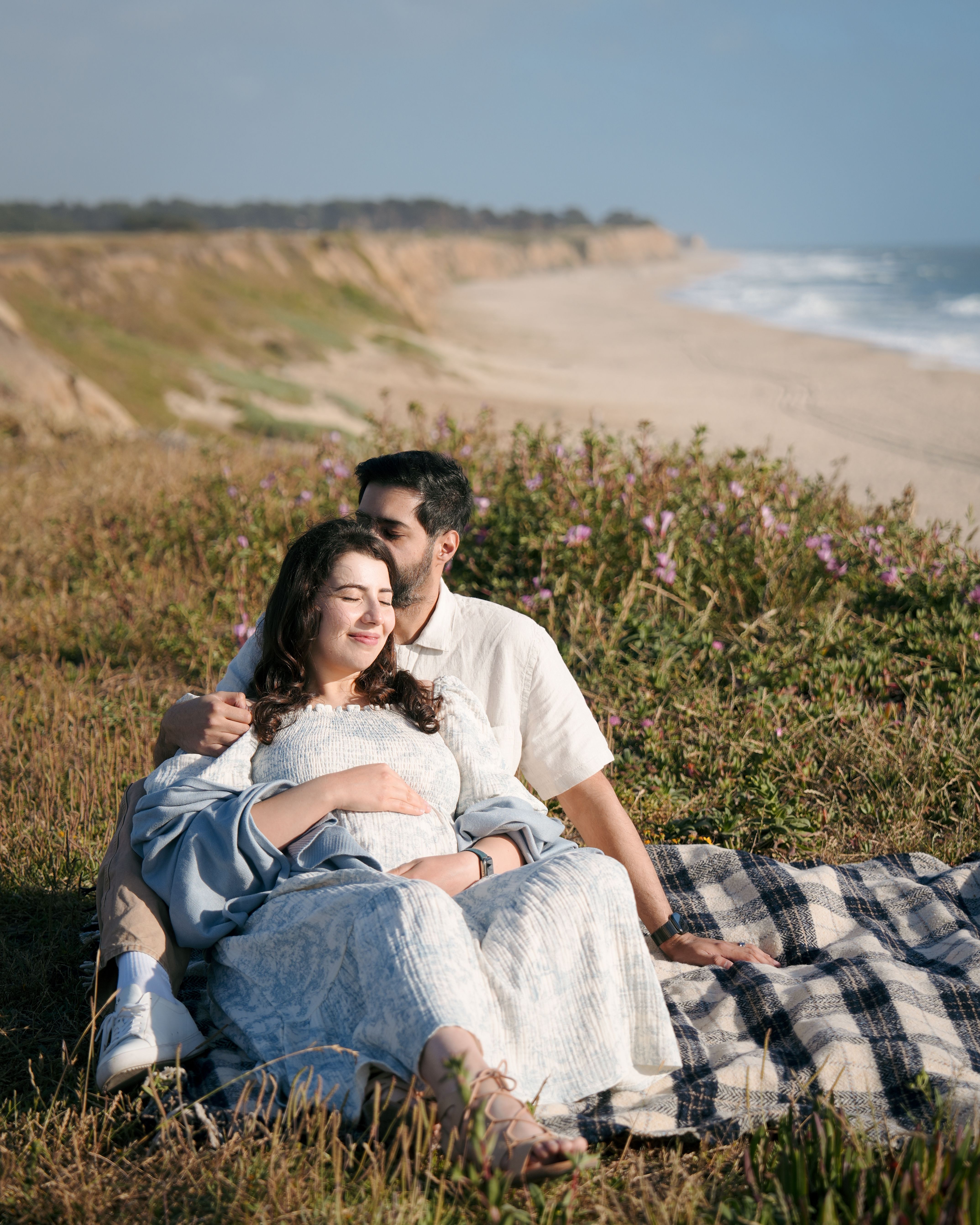 Seated maternity portrait on the shore in El Granada, California