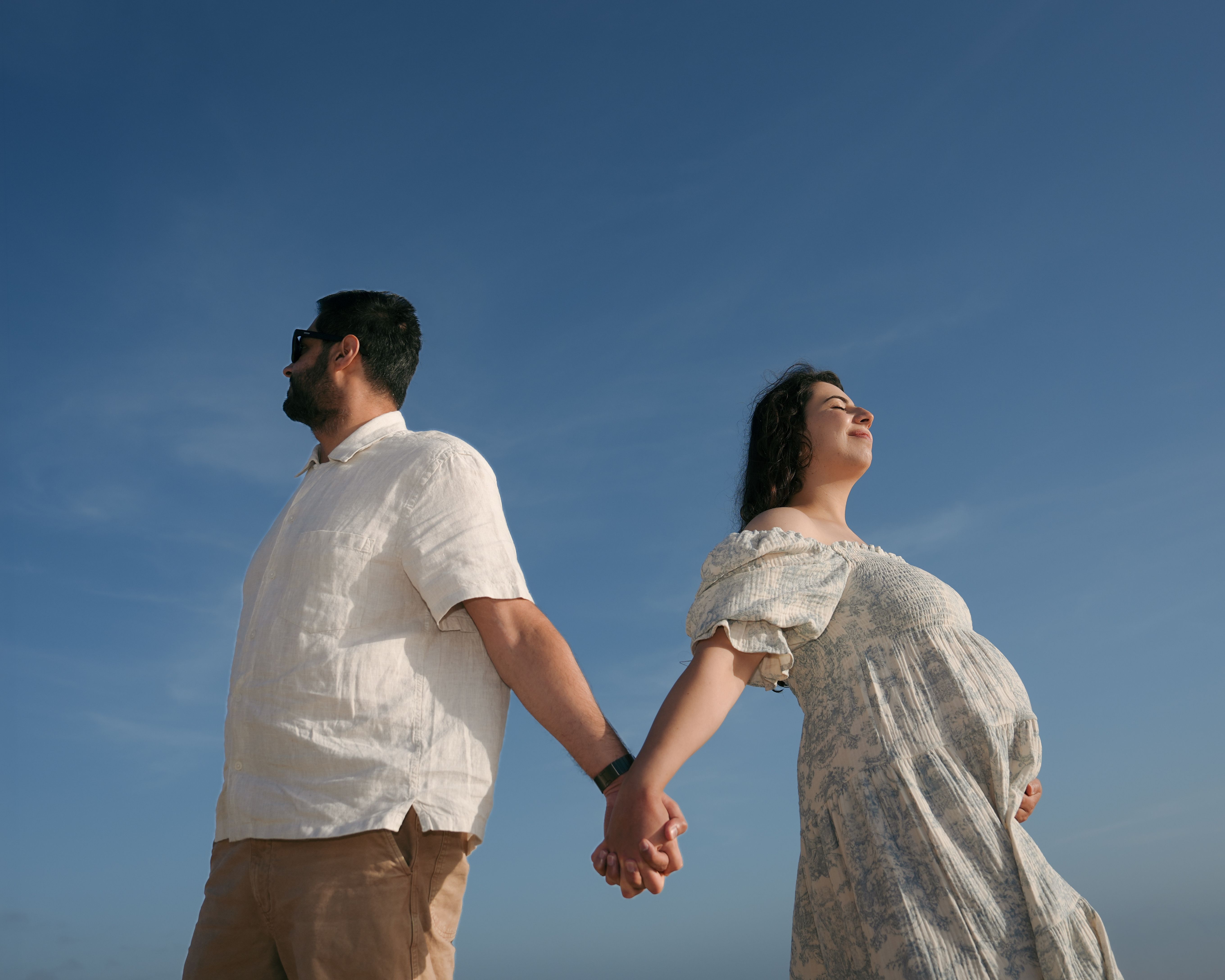 Skyward maternity handhold portrait in Bolinas, California